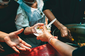 Volunteers share food aid with the poor in the community.