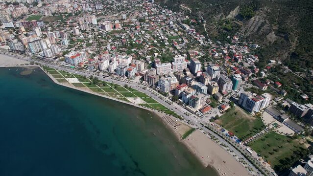 Aerial View of Vlora Coastal City: Stunning Beach Promenade and Bustling Port Along the Azure Blue Sea