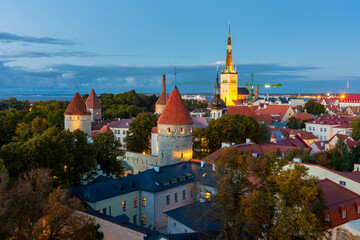 Classic Tallinn cityscape with Saint Olav's church and old town walls and towers at sunset, Estonia