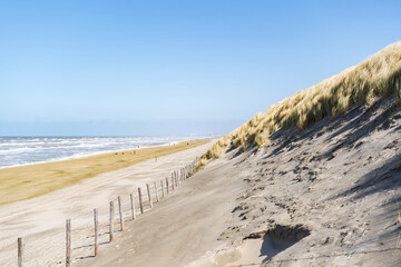 view of sand dunes and beach at north sea in the netherlands