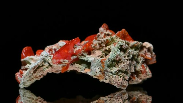 Wulfenite crystals specimen rotating slowly against a black background.