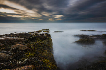 Fototapeta na wymiar Sunset at a rocky shore in New England, long exposure shot