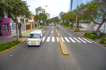Carro branco passando sobre faixa de pedestres em Lima, Peru.  - obrazy, fototapety, plakaty