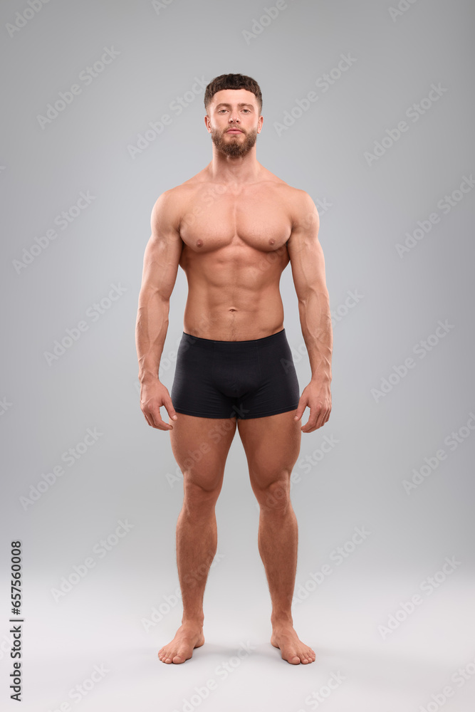 Wall mural Handsome muscular man on light grey background. Sexy body