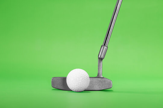 Golf Putter with Golf Ball isolated on a Green Background