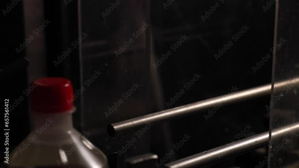 Poster close up vinegar bottles moving along an automated conveyor belt at a vinegar processing factory.