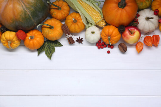 Happy Thanksgiving day. Flat lay composition with pumpkins on white wooden table, space for text