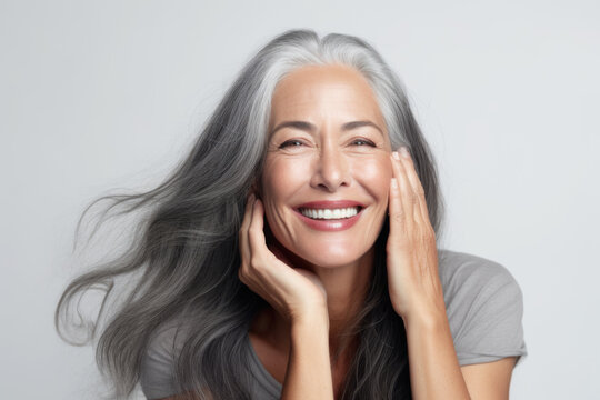 Portrait of a beautiful ageing mature woman with long grey hair. Healthy face and skin care beauty, cosmetics, cosmetology concept.