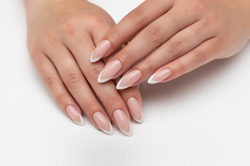 Wedding manicure on long sharp nails. White French manicure. Close-up on white background