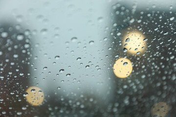 Raindrops on windowpane during a rainy day, capturing the tranquility and melancholy of nature's...