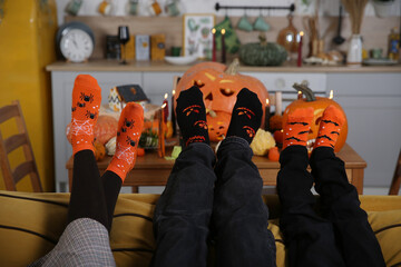 Socks. Family is celebrating Halloween together. Halloween fall party. Decor with lights, candles and pumpkins. Pumpkin jack-o'-lantern. Halloween decoration at home, indoor. Autumn Halloween decor