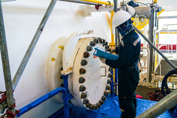 Engineer inspects large high pressure tanks in petroleum industry for maintenance.