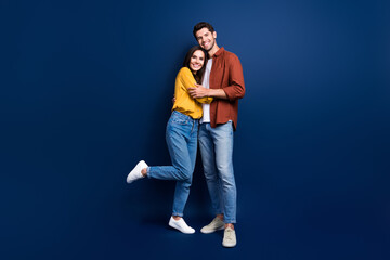 Full body portrait of two peaceful positive people good mood cuddle isolated on dark blue color...