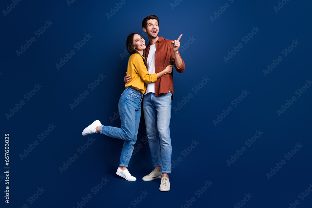 Aufkleber Full size portrait of two positive nice partners cuddle look direct finger empty space ad isolated on blue color background