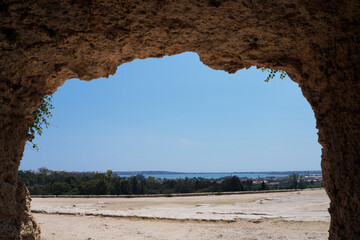 Stone room in artificial cave of ancient Greek theater in Archaeological Park. Parco Archeologico della Neapolis of Syracuse city, Sicily