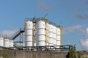 Obraz premium Weiße, runde Lagersilos im Hafen