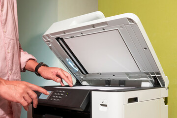 office worker and his cats printing paper on a multifunction laser printer in home office documents...