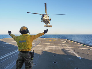 Navy helicopter landing on warship