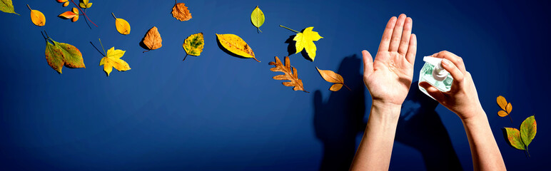 Applying sanitizer gel with autumn leaves - healthcare and hygiene concept - obrazy, fototapety, plakaty