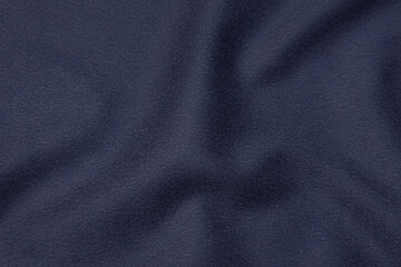 Blue dark monochrome natural wool fabric. Close up texture of the fabric is useful as a background.