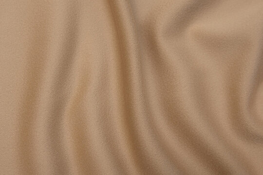Classic natural beige or brown wool fabric textured background. Expensive men's coat fabric.