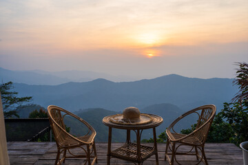 Rattan table and chairs in the morning with mountain view, beautiful sunlight in nature.
