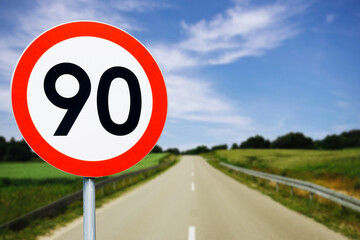 Speed limit sign with trees behind. Maximum ninety kilometers per hour. Safety on road background....
