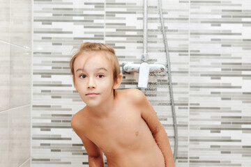 Boy washing himself in shower. Healthy childhood, lifestyle concept.
