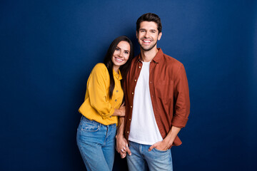 Portrait of idyllic cheerful partners toothy smile cuddle hold arms isolated on dark blue color background