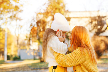 Lovely girl with her mom hugging on autumn walk. Autumn holidays, lifestyle.