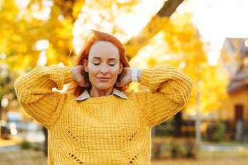 Redhead woman enjoying life outdoors. Happy woman walking in autumn park. Autumn fashion, lifestyle and holidays.