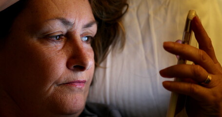 Woman staring at smartphone screen at night © Marco