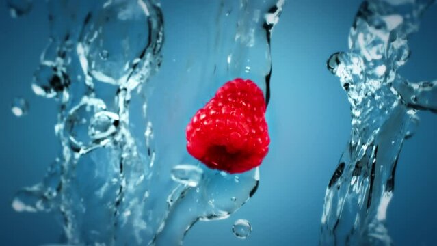 Fruit and berries tossed in the air and falling down in slow motion. Clear water splash and water droplets. Raspberry tossed in the air with water droplet splash falling down