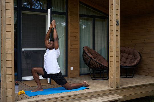 African American man performs an asana on a karimat