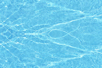 Defocus blurred transparent blue colored clear calm water surface texture with splashes reflection. Trendy abstract nature background. Water waves in sunlight with copy space. Blue watercolor shine.