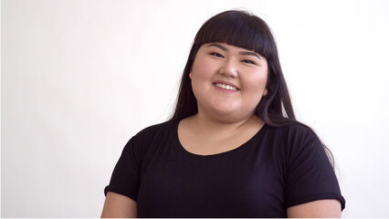 Young Beautiful Overweight Asian Girl On White Background Smiling. Happy - obrazy, fototapety, plakaty
