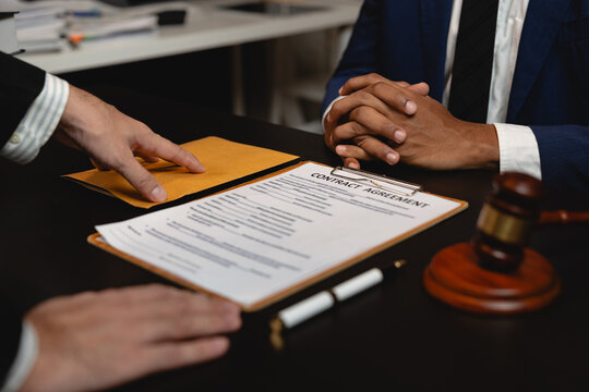 Businessman hands money envelope to lawyer in bribe over illegal business contract documents Investing, accepting bribes, corruption, fraud, unfairness, violation of ethics.