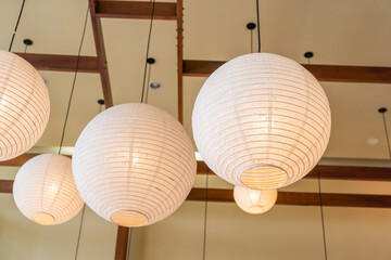 Modern ceiling lamp applied from bamboo and mulberry paper Japan style interior lighting bulbs decoration contemporary. Japanese Lantern at restaurant. Selective Focus