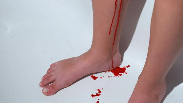 Girl with blood. Blood flows down the girl's legs. A girl has monthly blood.