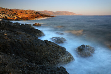 Fototapeta na wymiar Morning Sunlight and splashing waves near Sissi, Crete, Greece.