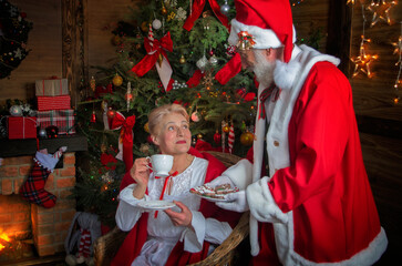 Santa Claus and wife Mrs. Claus near fireplace