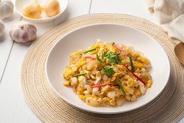 Stir fried Glass Noodles with pickled garlic and egg in white plate