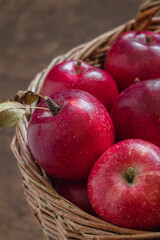 Fresh red apples close up in a wicker basket.