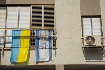 Israel supports Ukraine concept. Flags of Israel and Ukraine on the window on building.