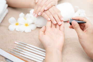 Woman receive care service by professional Beautician Manicure at spa centre. Nail beauty salon use nail file for Glazing treatment. manicurist make nail customer to beautiful. body care spa treatment - obrazy, fototapety, plakaty