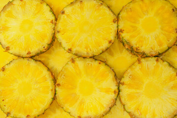 Pineapple juicy yellow slices as a background.