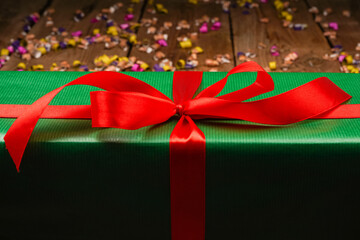 Christmas gift boxes with copy space. Green gift with red ribbon on wooden background. Happy new year concept.