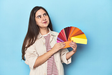 Chic designer woman with a color palette on blue background