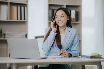 Fototapeta na wymiar Happy Asian businesswoman working in modern office using laptop computer
