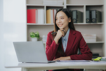Asian businesswoman working with documents and smiling happily while working in the office Business success and celebration concept